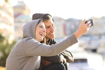 Young man and woman taking a selfie together after composite filings, Roseville NSW