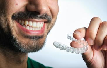 Man holding clear aligner in his hand, Roseville NSW
