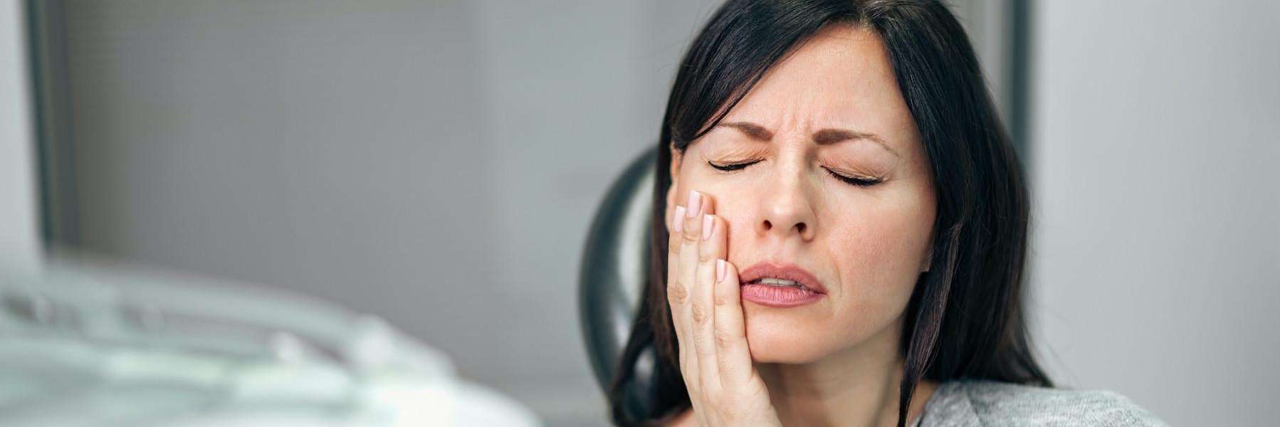 Woman holding mouth, in need of emergency dental care, Roseville NSW
