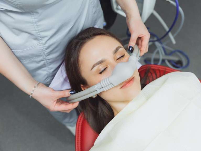 A woman in a dentist patient chair utilizing nitrous oxide sedation, Roseville NSW 